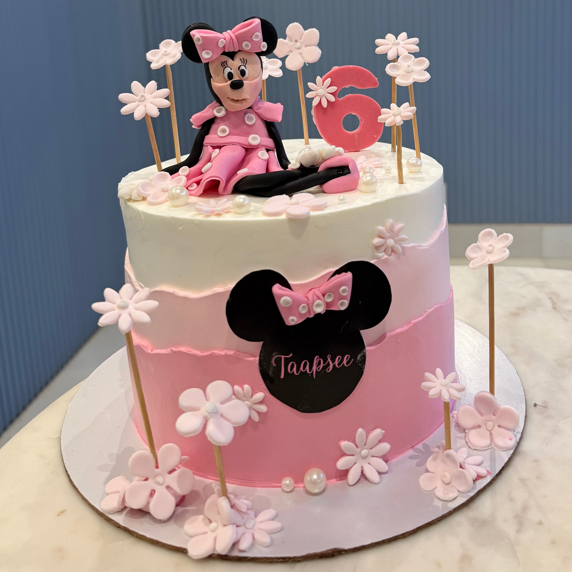 A 1.5kg Belgstrew Minnie Mouse cake with a pink polka-dot bow and a personalized gold name tag.