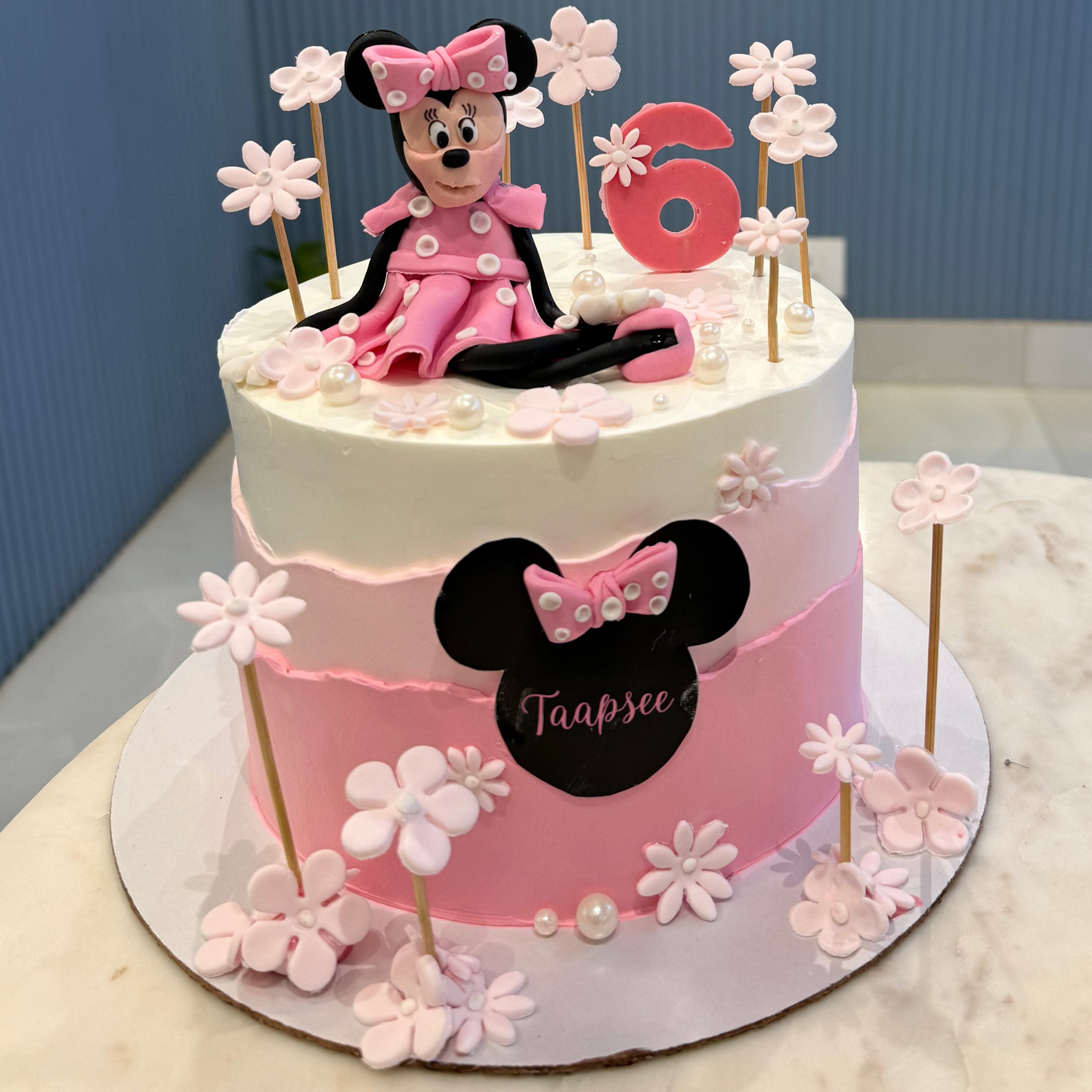 A 1.5kg Belgstrew Minnie Mouse cake with a pink polka-dot bow and a personalized gold name tag.