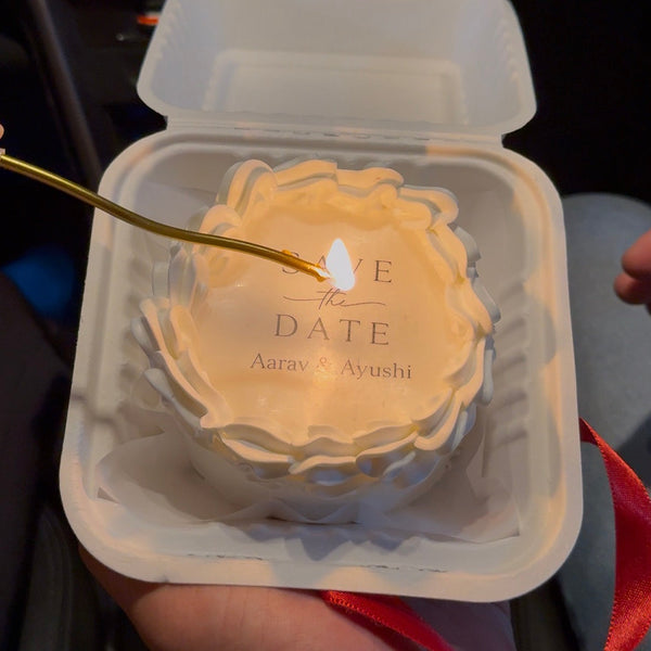 A 300g Belgstrew bento cake with a "Save the Date" fire paper top layer being lit to reveal a wedding date underneath.