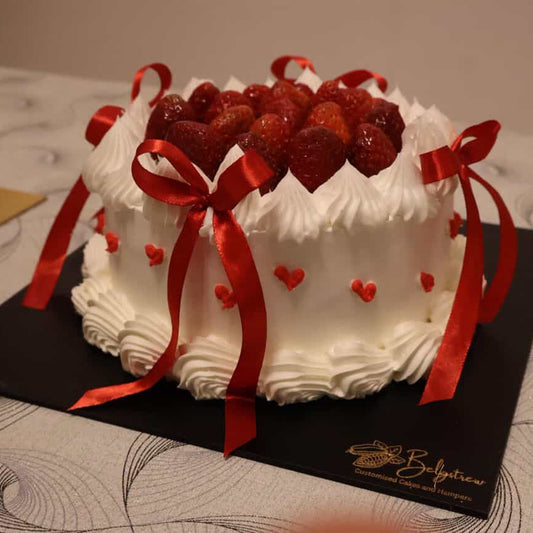 A bespoke Belgstrew Chocolate Truffle cake overflowing with fresh red strawberries and decorated with romantic gold heart accents.