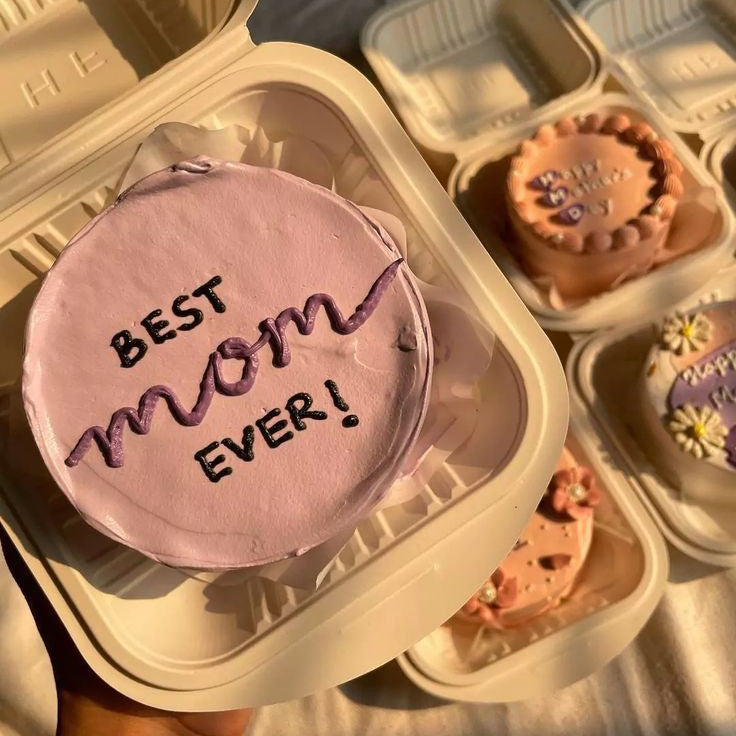 A lilac minimalist bento cake in a sustainable box with "Best Mom Ever" hand-piped in dark purple cream, part of the Belgstrew Mother's Day collection.