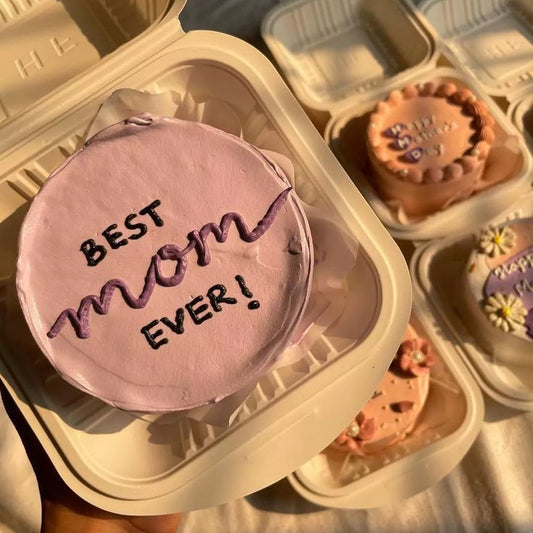 A lilac minimalist bento cake in a sustainable box with "Best Mom Ever" hand-piped in dark purple cream, part of the Belgstrew Mother's Day collection.