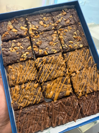 Box of brownies with caramel drizzle held by a hand