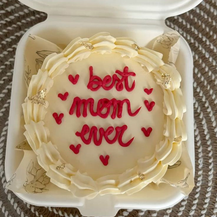 Ivory vintage piped Mother's Day bento cake with gold leaf accents and "best mom ever" written in red icing.