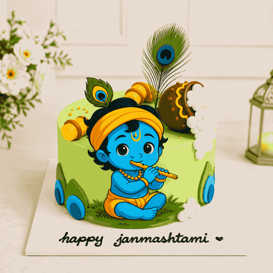 A round pastel green celebration cake featuring a cute illustrated baby Krishna playing a flute, decorated with an overflowing butter pot and a real peacock feather.