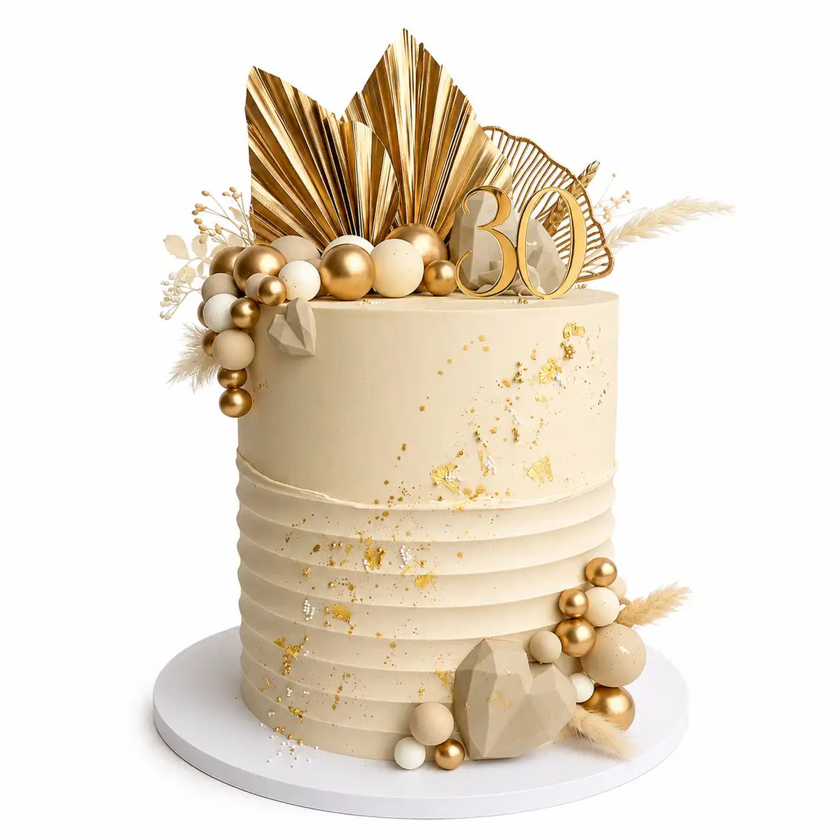 A tall, premium round 30th birthday cake with a smooth white top tier and a horizontally pleated white bottom tier, decorated with gold leaf, gold and nude spheres, geometric chocolate hearts, dried grass, and gold fan palms as seen in image.
