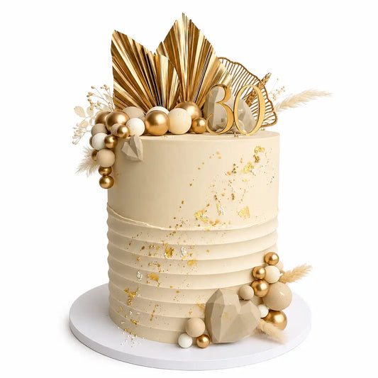 A tall, premium round 30th birthday cake with a smooth white top tier and a horizontally pleated white bottom tier, decorated with gold leaf, gold and nude spheres, geometric chocolate hearts, dried grass, and gold fan palms as seen in image.