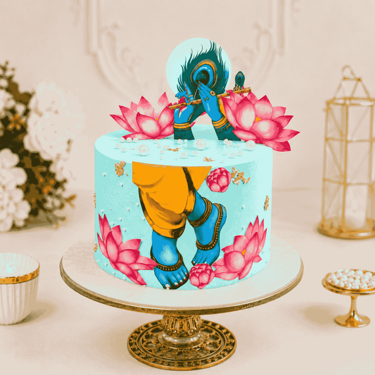 A tall aqua turquoise festive cake decorated with an artistic illustration of Lord Krishna, blooming pink lotuses, a peacock feather, and a golden flute.