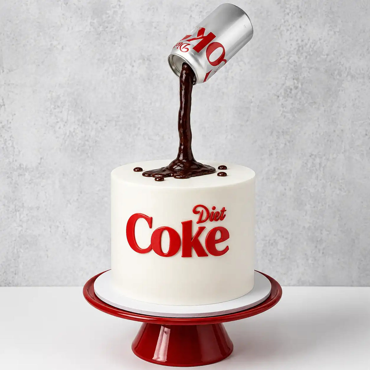A tall round minimalist white cake featuring a gravity defying illusion with a silver diet coke can floating in the air and pouring a stream of dark cola onto the top, with red 3D logo text on the front as seen in image.