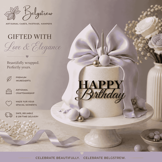 A tall ivory textured celebration cake decorated with a large sculpted lilac lavender bow, purple and gold spheres, a slender gold candle, and a black Happy Birthday topper.