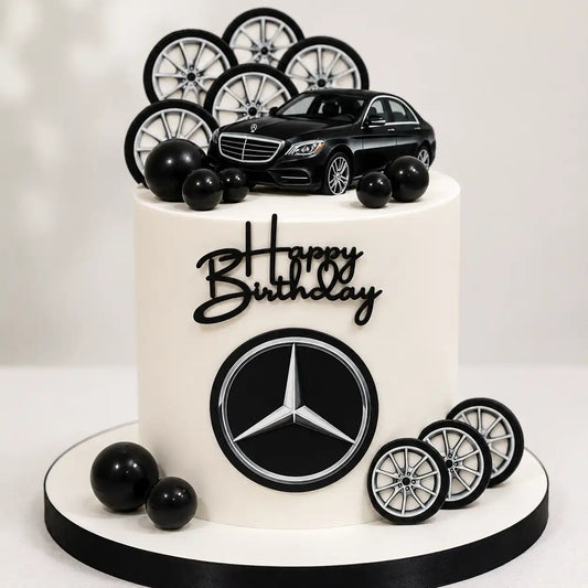 A tall round premium white birthday cake featuring a prominent black Mercedes star logo emblem on the front, decorated with high-gloss black spheres, a black luxury sedan cutout, and multiple alloy wheel graphics on top and around the base as seen in image.